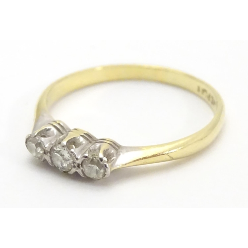 448 - An 18ct gold ring set with trio of diamonds. Ring size approx M