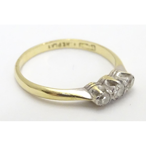 448 - An 18ct gold ring set with trio of diamonds. Ring size approx M