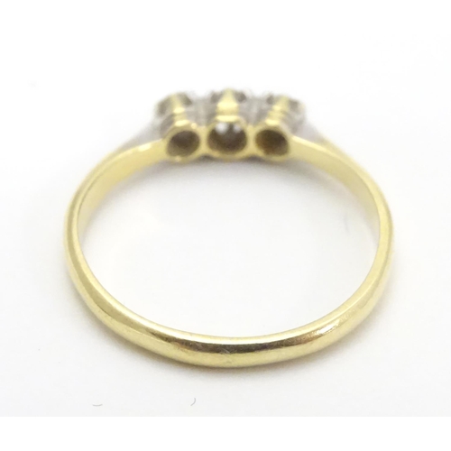 448 - An 18ct gold ring set with trio of diamonds. Ring size approx M