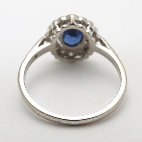 450 - An 18ct white gold ring set with central sapphire bordered by diamonds