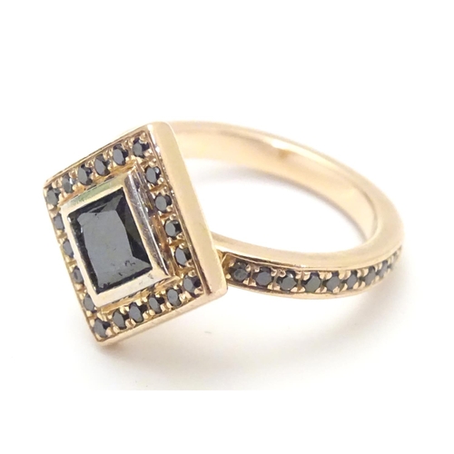 465 - A 14ct rose gold ring set with central princess cut black diamond bordered by round brilliant cut di... 