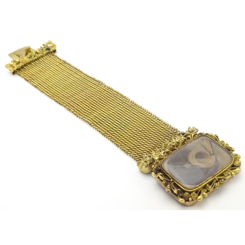 477 - Mourning / Memorial jewellery : A 19thC gilt metal mourning bracelet of cuff form with wide chain li... 