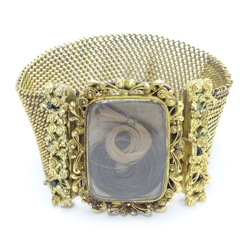 477 - Mourning / Memorial jewellery : A 19thC gilt metal mourning bracelet of cuff form with wide chain li... 