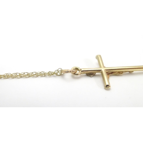 479 - A 9ct gold pendant formed as a crucifix set with single diamond on a 18