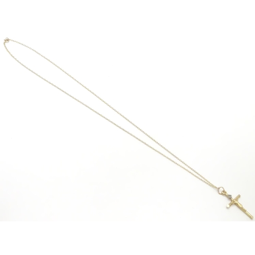 479 - A 9ct gold pendant formed as a crucifix set with single diamond on a 18