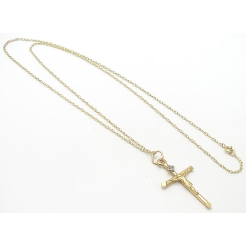 479 - A 9ct gold pendant formed as a crucifix set with single diamond on a 18