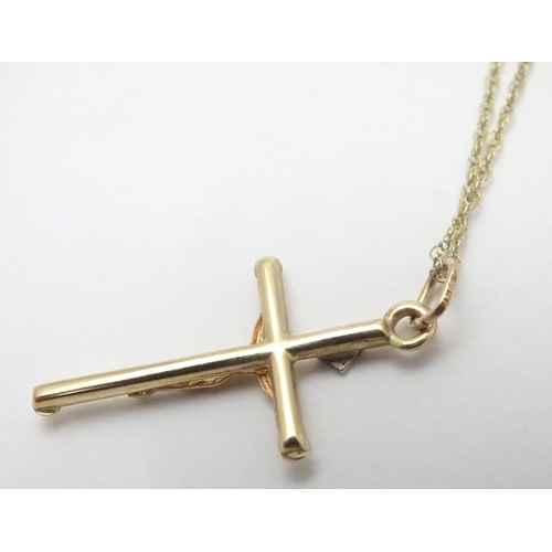 479 - A 9ct gold pendant formed as a crucifix set with single diamond on a 18