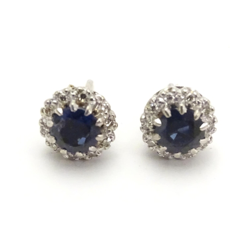 481 - A pair of 9ct white gold stud earrings set with central blue spinel bordered by white stones in a cl... 