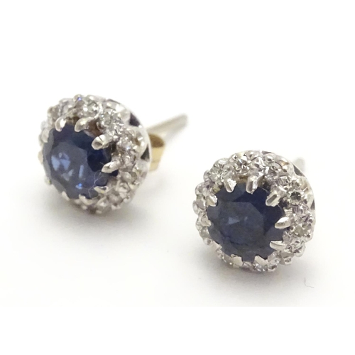 481 - A pair of 9ct white gold stud earrings set with central blue spinel bordered by white stones in a cl... 