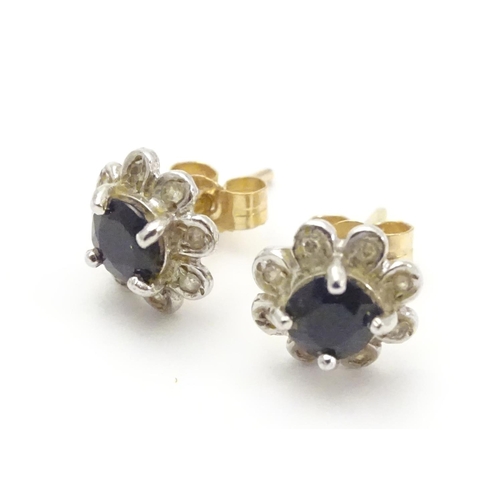 482 - A pair of 9ct gold stud earrings set with central blue stone bordered by chip set diamonds. Approx. ... 