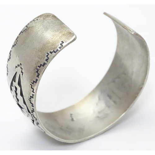 484 - A North American bangle formed bracelet with incised geometric decoration. Marked Sterling