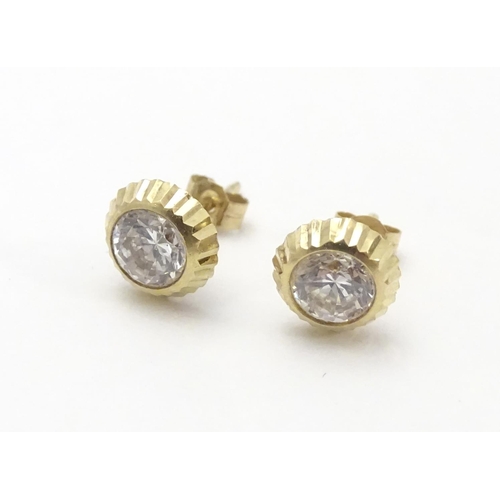 486 - A pair of 9ct gold stud earrings set with paste stones. Approx. 1/4