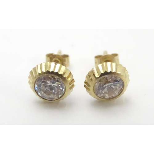 486 - A pair of 9ct gold stud earrings set with paste stones. Approx. 1/4