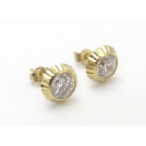 486 - A pair of 9ct gold stud earrings set with paste stones. Approx. 1/4