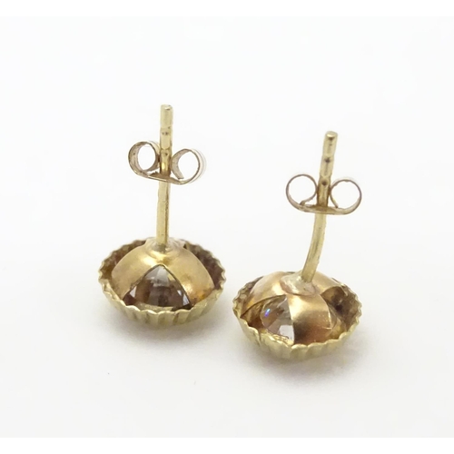 486 - A pair of 9ct gold stud earrings set with paste stones. Approx. 1/4