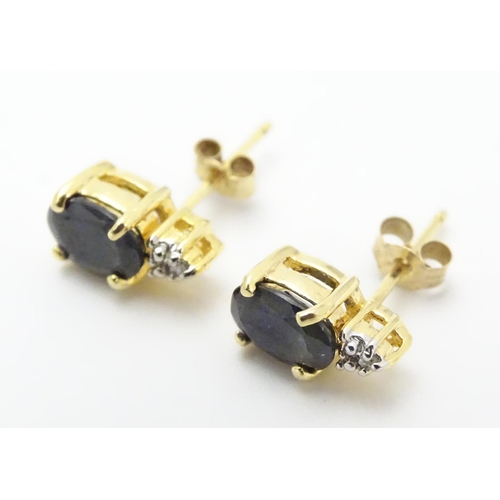 490 - A pair of silver gilt stud earrings set with blue and white stones. Approx. 3/8