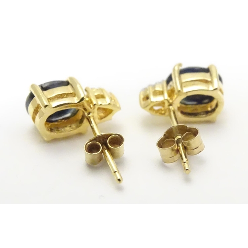 490 - A pair of silver gilt stud earrings set with blue and white stones. Approx. 3/8