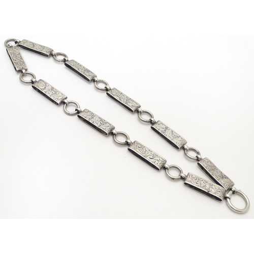 494 - A Victorian white metal book chain necklace with engraved decoration. Approx. 15