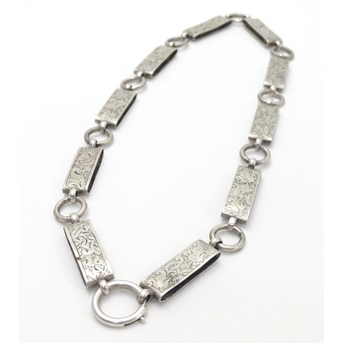 494 - A Victorian white metal book chain necklace with engraved decoration. Approx. 15