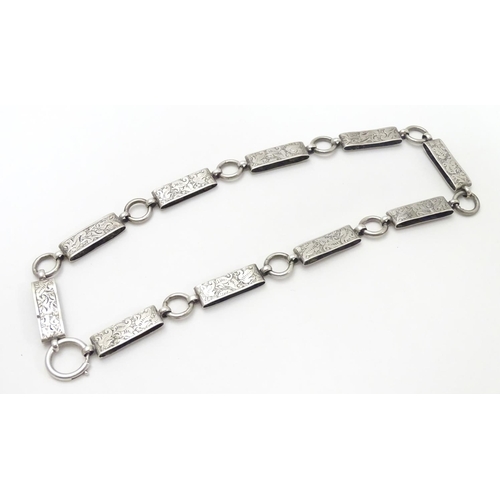 494 - A Victorian white metal book chain necklace with engraved decoration. Approx. 15