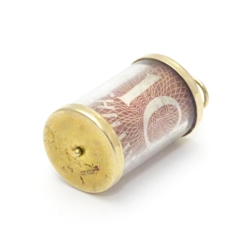 495 - A 9ct gold novelty pendant / charm of cylindrical form with rolled 10 shilling note to centre. Appro... 