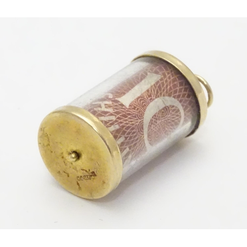 495 - A 9ct gold novelty pendant / charm of cylindrical form with rolled 10 shilling note to centre. Appro... 