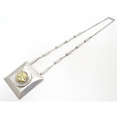 499 - An unusual silver necklace with large square pendant with hammered decoration and silver gilt face t... 