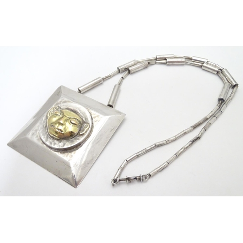 499 - An unusual silver necklace with large square pendant with hammered decoration and silver gilt face t... 