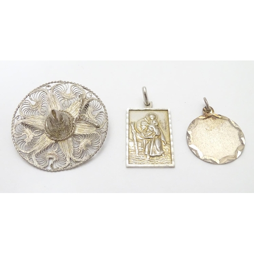 502 - Two silver pendants comprising a St Christopher of rectangular form stamped Sterling Silver, JAM, an... 