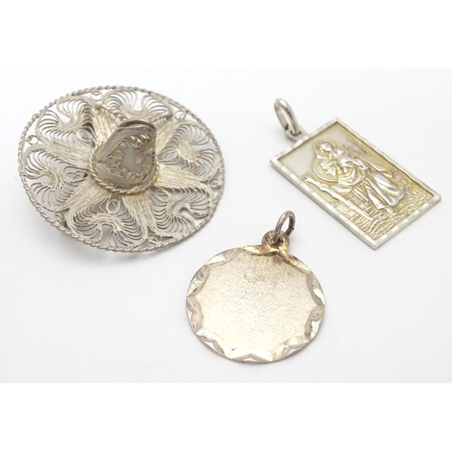 502 - Two silver pendants comprising a St Christopher of rectangular form stamped Sterling Silver, JAM, an... 