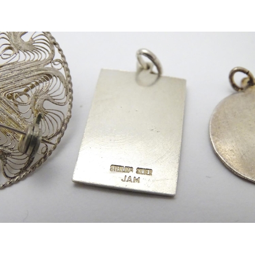 502 - Two silver pendants comprising a St Christopher of rectangular form stamped Sterling Silver, JAM, an... 