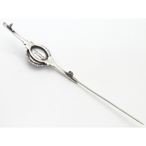 505 - A silver bar brooch, the central circular section mounted with butterfly wing detail behind glass. M... 