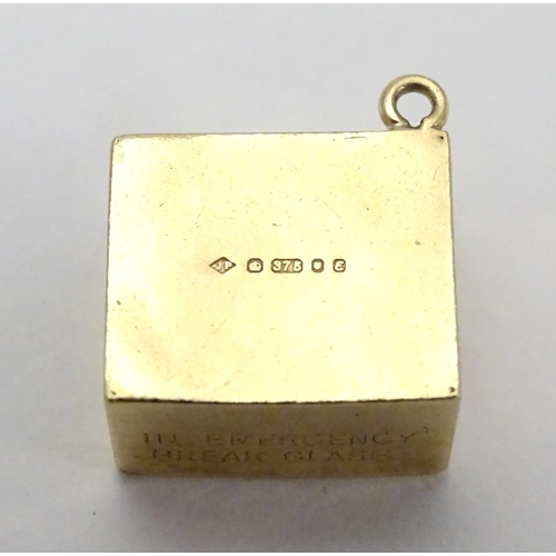 512 - A novelty 9ct gold pendant charm of squared form. Engraved ' In Emergency break glass' and containin... 