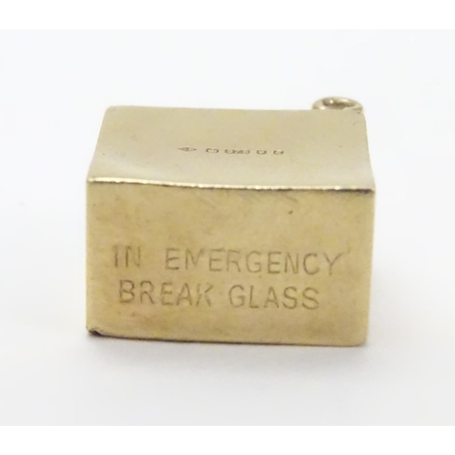 512 - A novelty 9ct gold pendant charm of squared form. Engraved ' In Emergency break glass' and containin... 