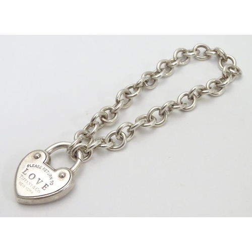 513 - A chain link bracelet with silver heart shaped padlock style clasp marked 'Love' ' Please return to ... 