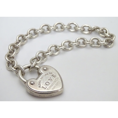 513 - A chain link bracelet with silver heart shaped padlock style clasp marked 'Love' ' Please return to ... 