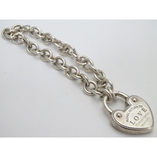 513 - A chain link bracelet with silver heart shaped padlock style clasp marked 'Love' ' Please return to ... 