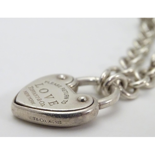 513 - A chain link bracelet with silver heart shaped padlock style clasp marked 'Love' ' Please return to ... 