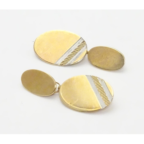 521 - A pair of 9ct gold cufflinks of oval form.