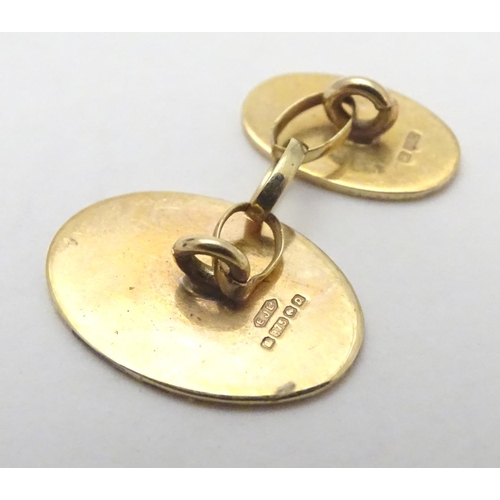 521 - A pair of 9ct gold cufflinks of oval form.