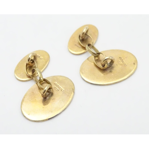 521 - A pair of 9ct gold cufflinks of oval form.