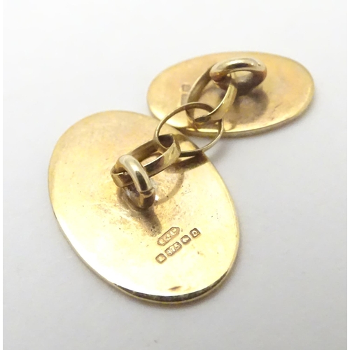 521 - A pair of 9ct gold cufflinks of oval form.