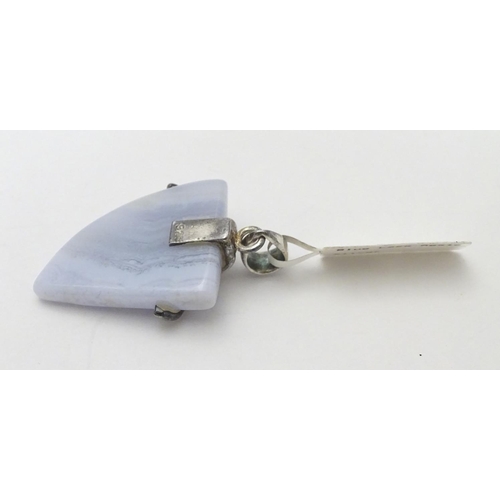 528 - A silver mounted hardstone set pendant, the polished Blue Lace Agate formed as a stylised shark’s to... 