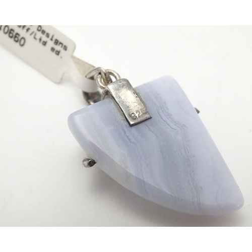 528 - A silver mounted hardstone set pendant, the polished Blue Lace Agate formed as a stylised shark’s to... 