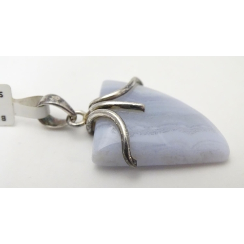 528 - A silver mounted hardstone set pendant, the polished Blue Lace Agate formed as a stylised shark’s to... 