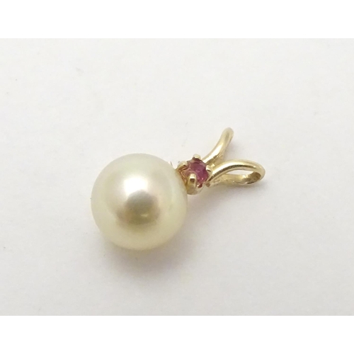 530 - A 9ct gold pendant set with pearl and red spinel. Approx 1 /4