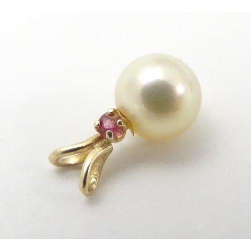 530 - A 9ct gold pendant set with pearl and red spinel. Approx 1 /4