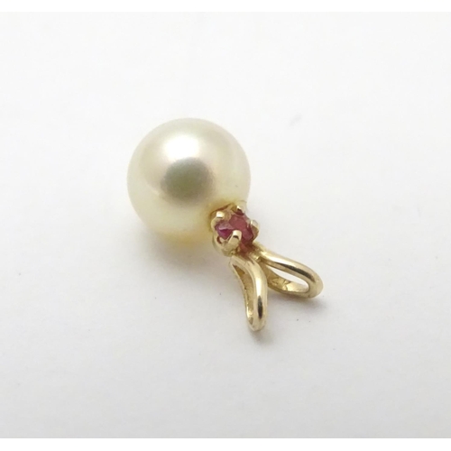 530 - A 9ct gold pendant set with pearl and red spinel. Approx 1 /4