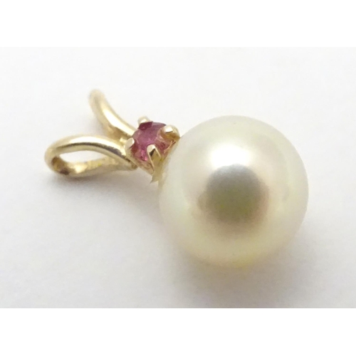 530 - A 9ct gold pendant set with pearl and red spinel. Approx 1 /4