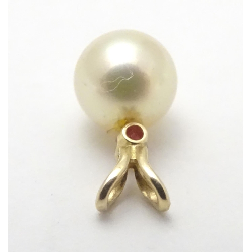 530 - A 9ct gold pendant set with pearl and red spinel. Approx 1 /4